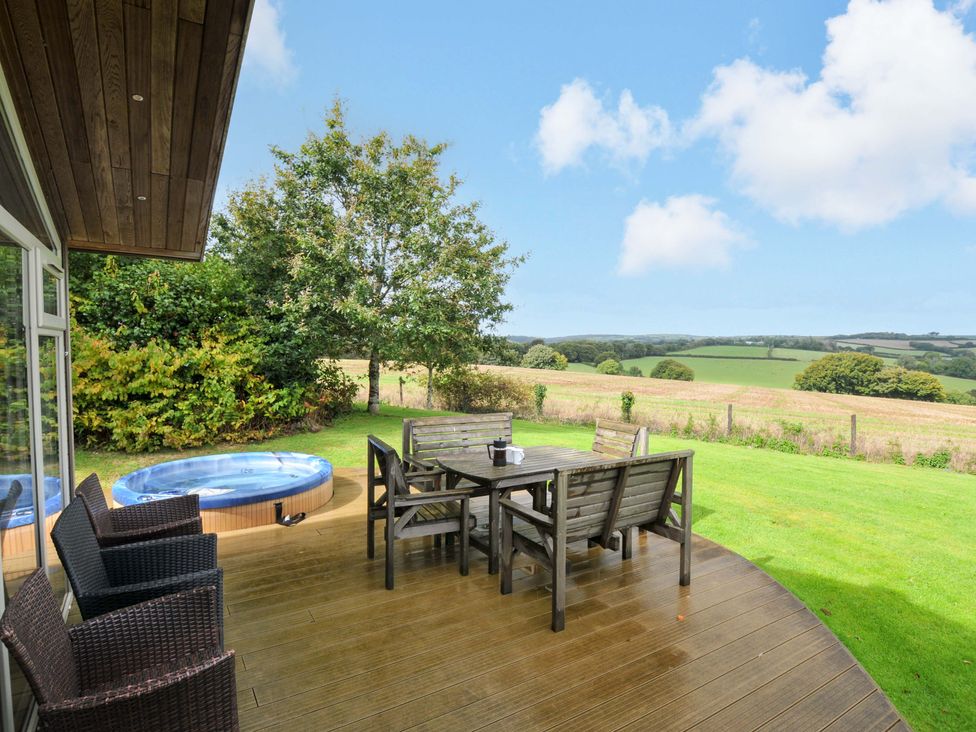 An outdoor area with a dining table and hot tub at 8 Horizon View in Dobwalls