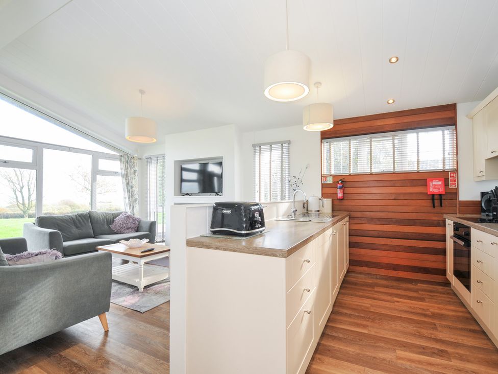 A living room with a sofa and kitchen area at 9 Horizon View in Dobwalls