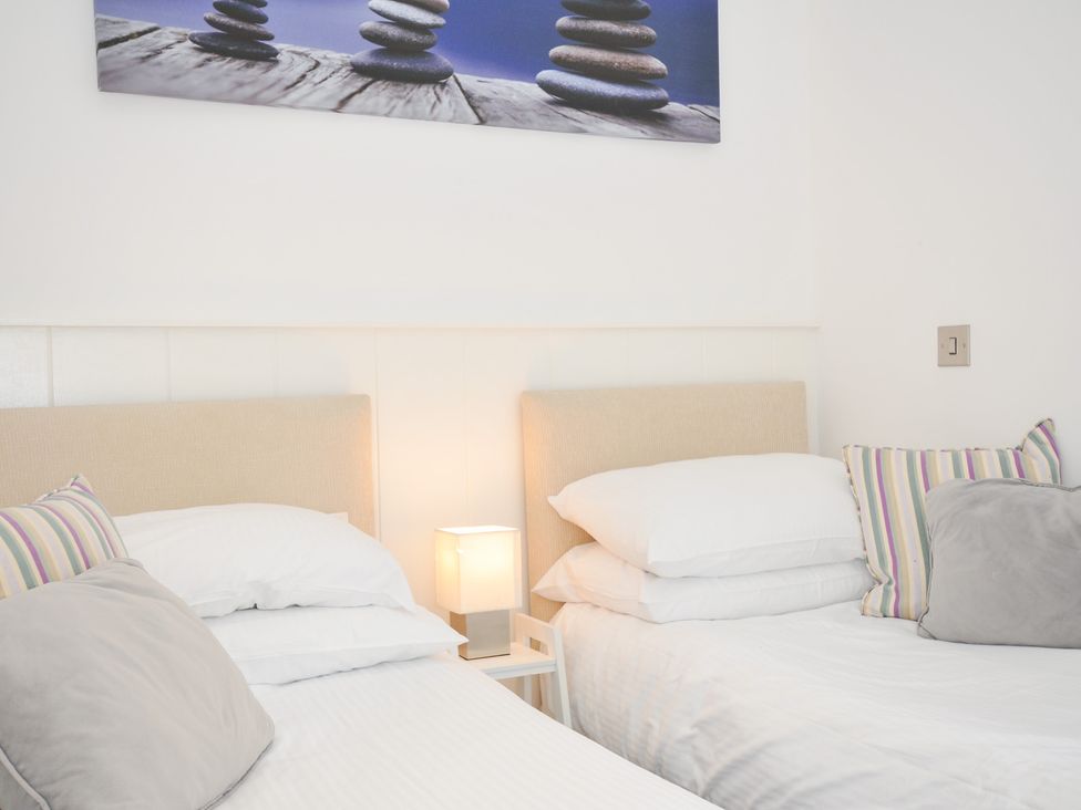 A bedroom with two beds and a bedside lamp at 9 Horizon View in Dobwalls