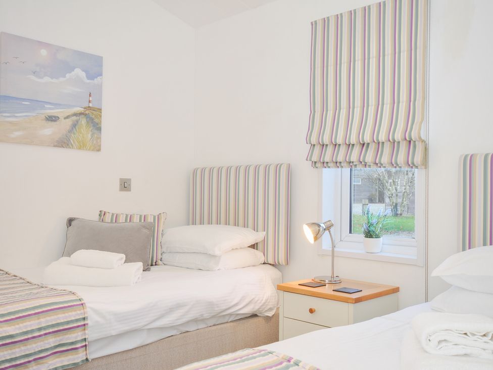 A bedroom with two beds and a lamp at 9 Horizon View in Dobwalls