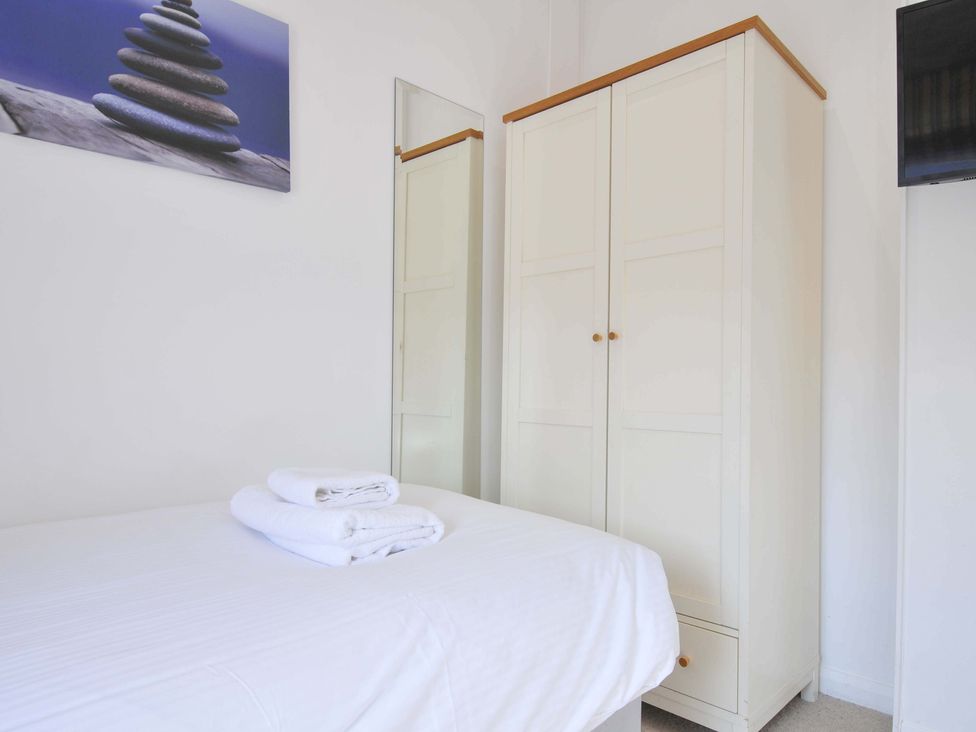 A bedroom with a bed, wardrobe, mirror and towels at 10 Horizon View in Dobwalls