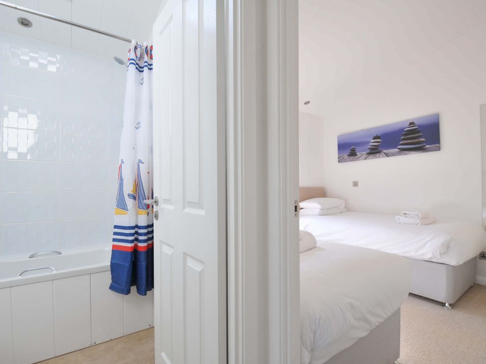A bathroom with a bathtub and a view into a bedroom at 10 Horizon View in Dobwalls