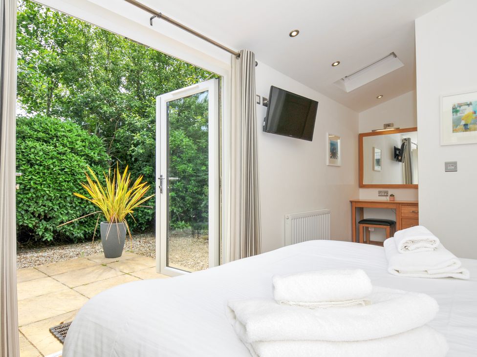A bedroom with a bed and a view of the garden at 15 Horizon View in Dobwalls