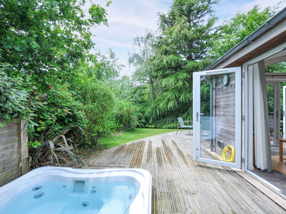 A garden with a hot tub and wooden deck at 15 Horizon View in Dobwalls