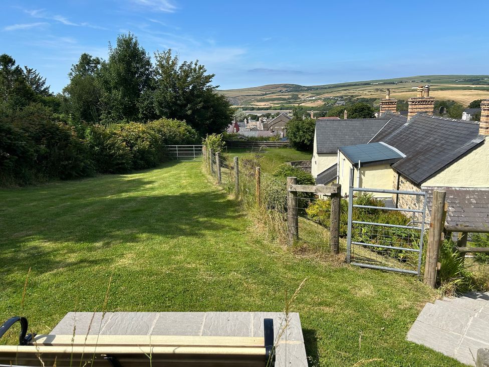 A garden area with a bench and a view of houses at Delfryn, Newport