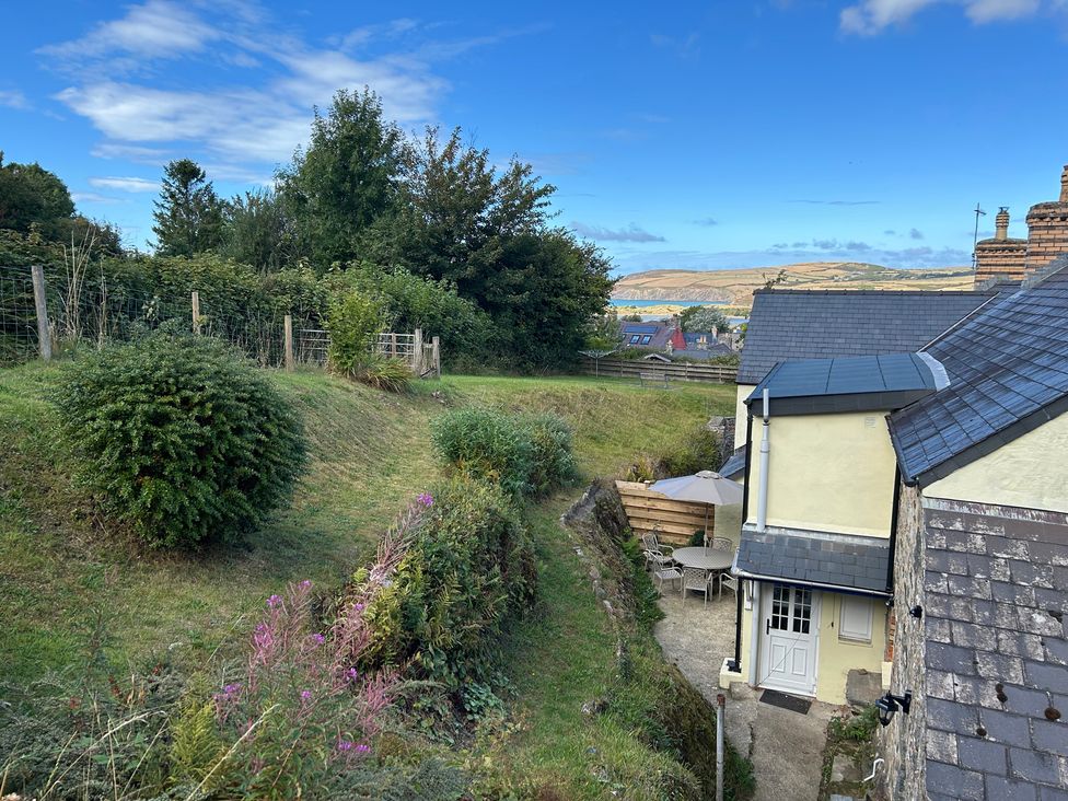 A garden with a table and chairs next to a house at Delfryn, Newport