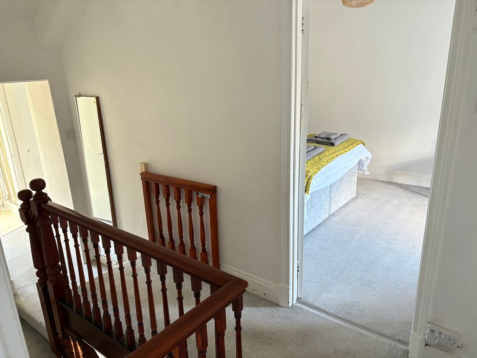 A hallway with a staircase and a door leading to a room at Delfryn, Newport
