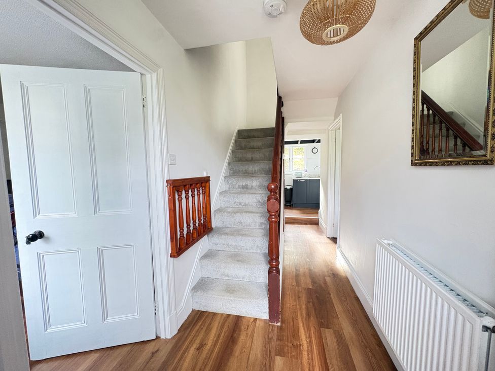 A hallway with a staircase and a door at Delfryn, Newport