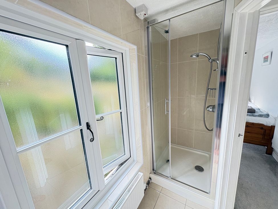 A bathroom with a shower and window at Delfryn, Newport