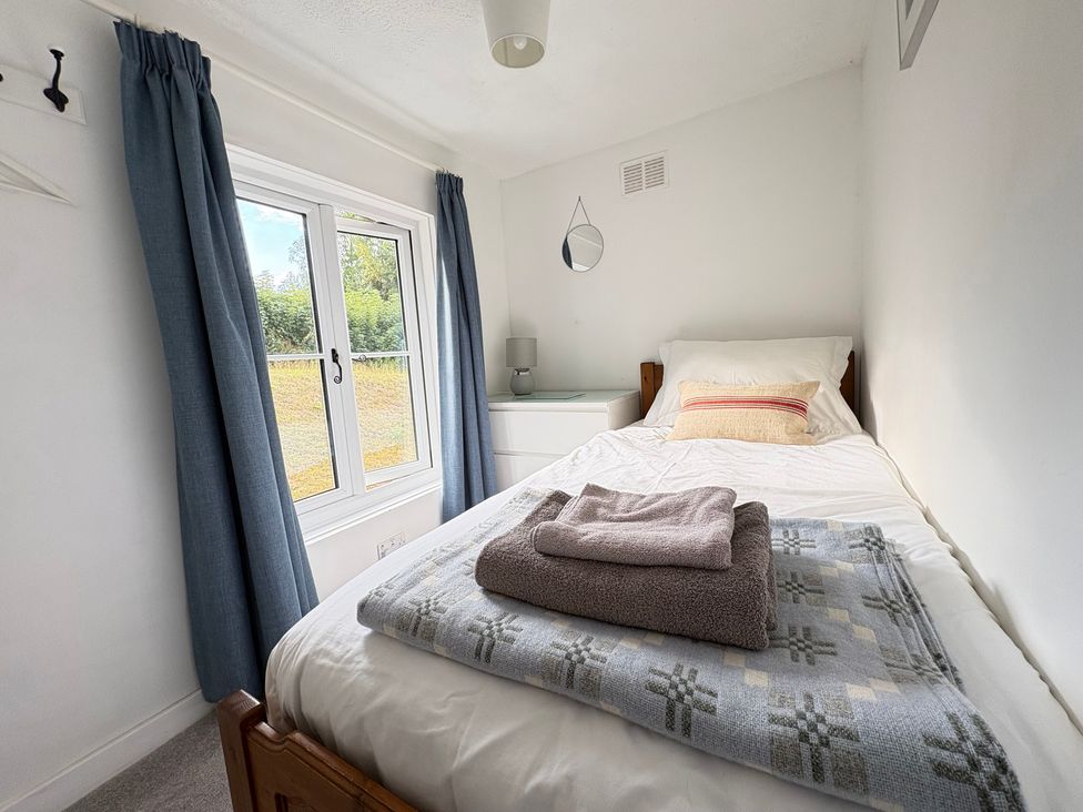A bedroom with a single bed and a window at Delfryn, Newport
