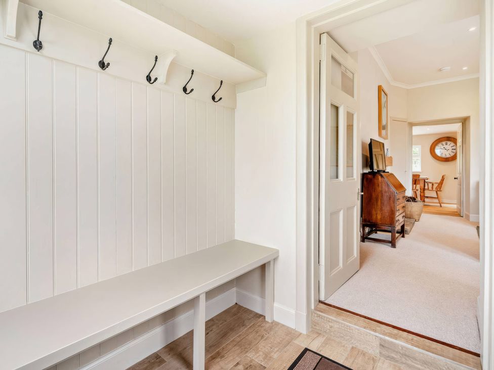 A hallway with hooks and a bench at Upper Hillside Cottage in Blairgowrie