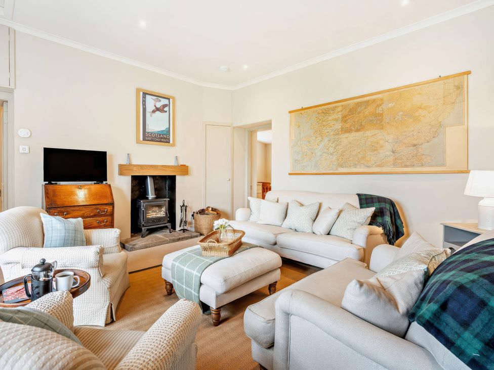 A living room with a sofa and fireplace at Upper Hillside Cottage in Blairgowrie