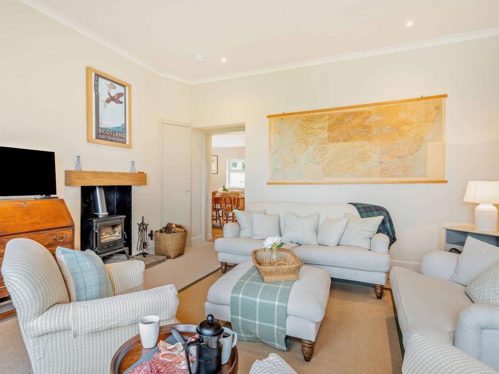 A living room with a fireplace and a map on the wall at Upper Hillside Cottage Blairgowrie