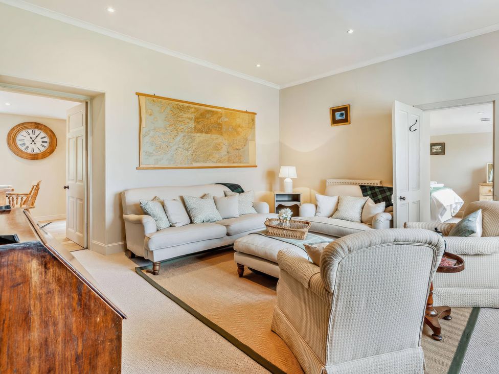 A living room featuring a sofa and armchair at Upper Hillside Cottage in Blairgowrie
