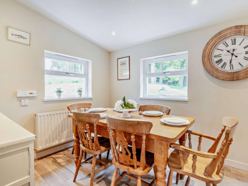 A dining room with a wooden table and chairs at Upper Hillside Cottage in Blairgowrie
