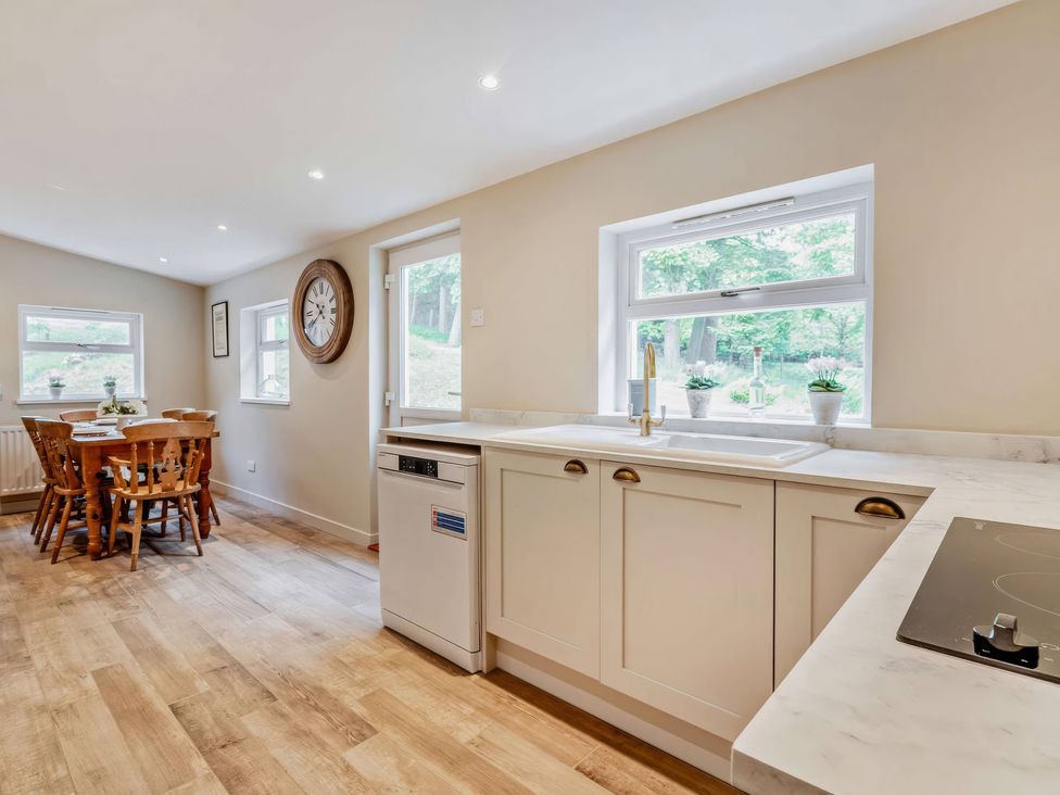 A kitchen with a table and chairs at Upper Hillside Cottage in Blairgowrie