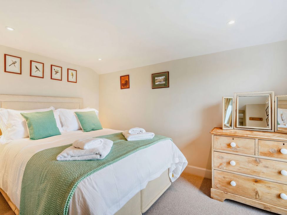A bedroom with a bed and a dresser at Upper Hillside Cottage in Blairgowrie