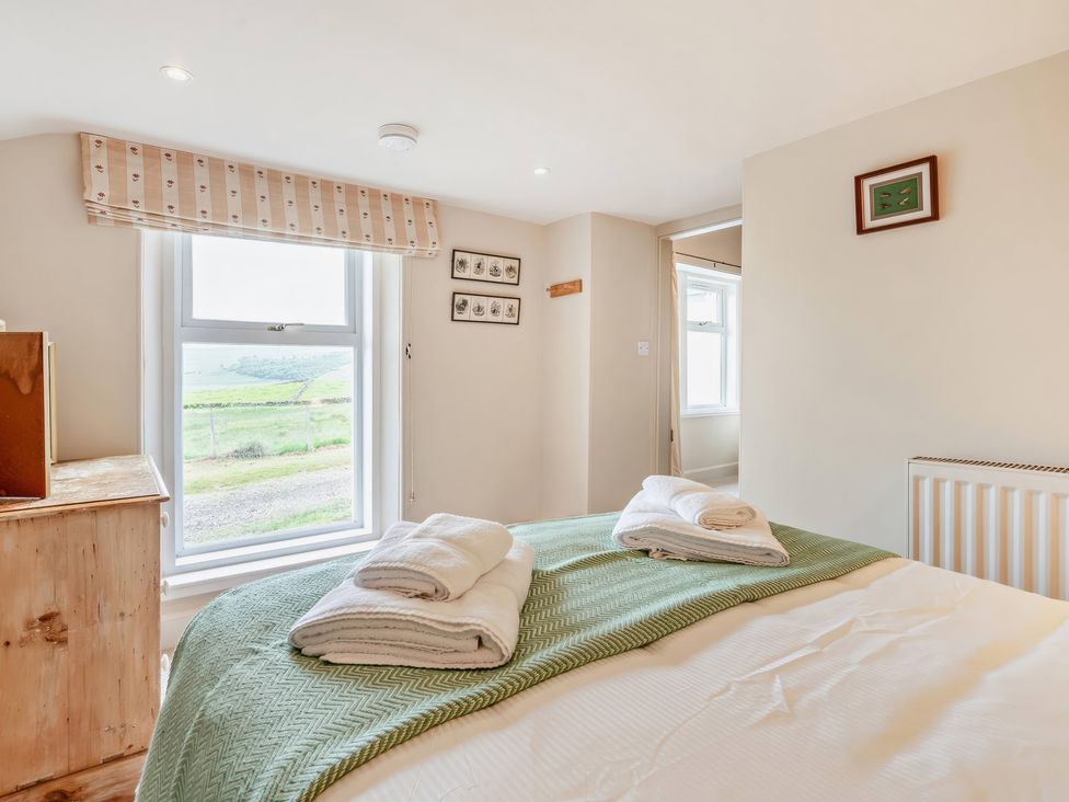 A bedroom with a bed and window at Upper Hillside Cottage Blairgowrie