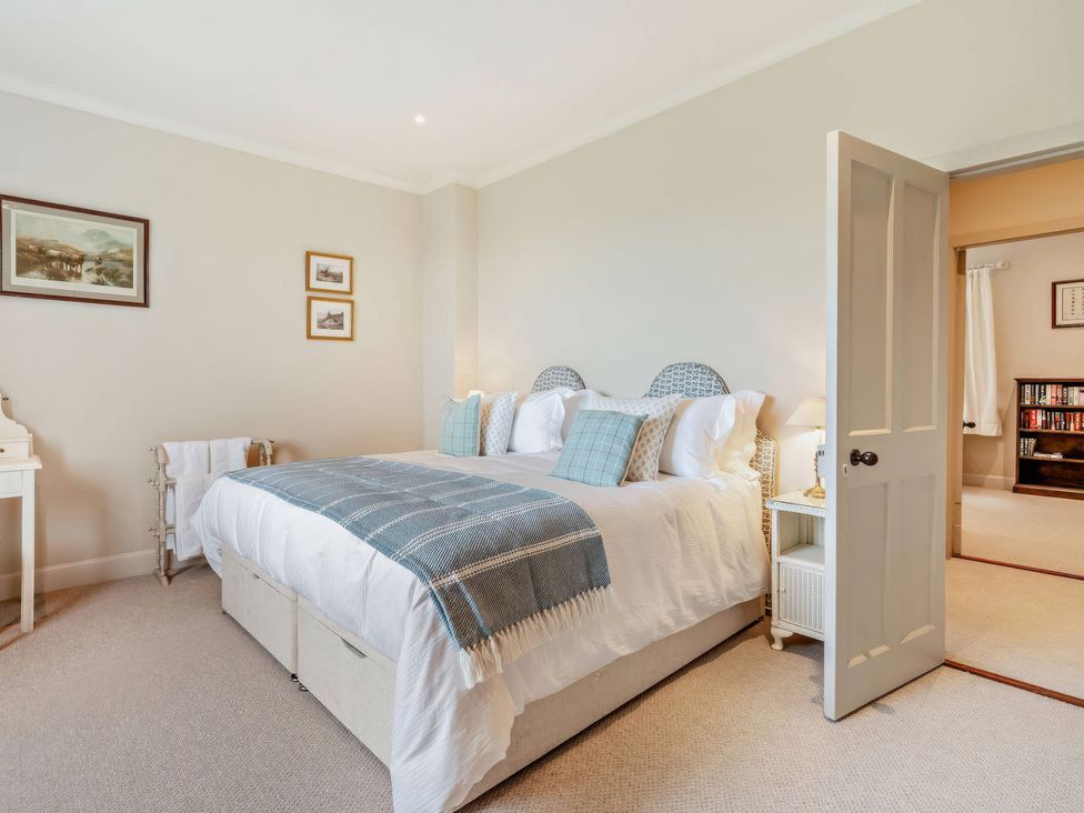 A bedroom with a bed and bedside tables at Upper Hillside Cottage in Blairgowrie