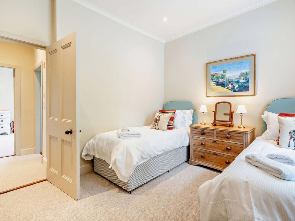 A bedroom with two beds and a dresser at Upper Hillside Cottage, Blairgowrie