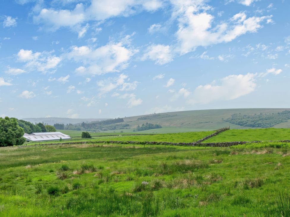 A landscape with fields and a farm building at Upper Hillside Cottage in Blairgowrie