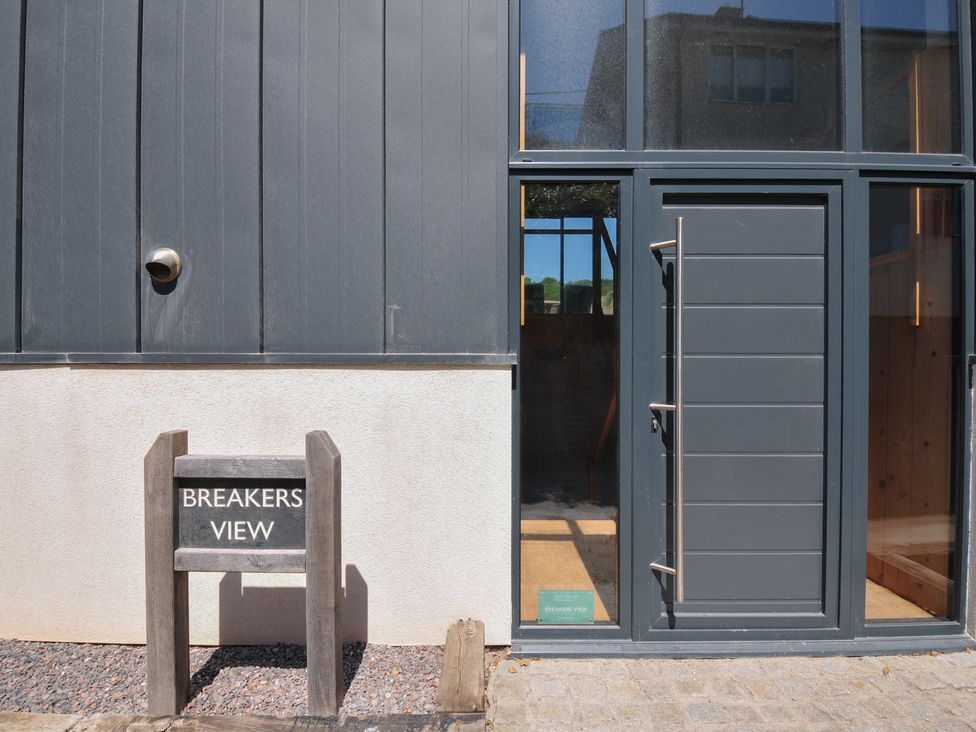 An exterior view of Breakers View with a sign at Polzeath
