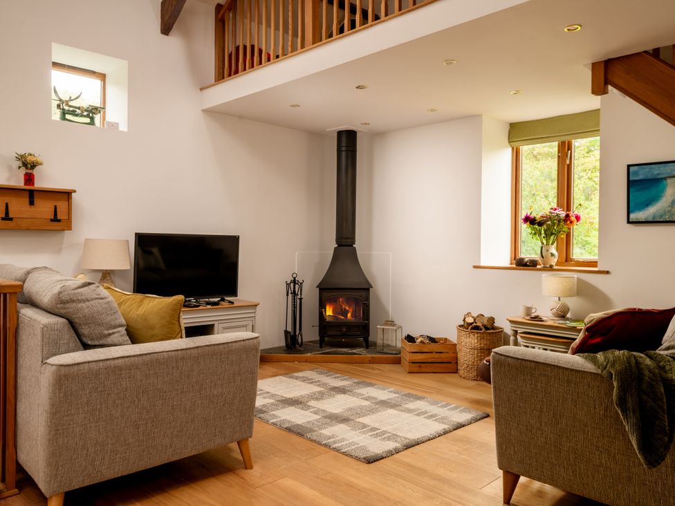 A living room with a fireplace and television at Hoppers Barn Pancrasweek near Holsworthy