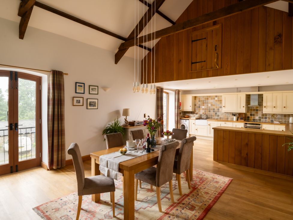 A kitchen and dining area with wooden features at Hoppers Barn Pancrasweek near Holsworthy