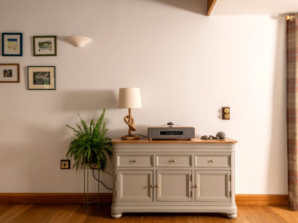 A living room with a media player and a lamp at Hoppers Barn Pancrasweek near Holsworthy