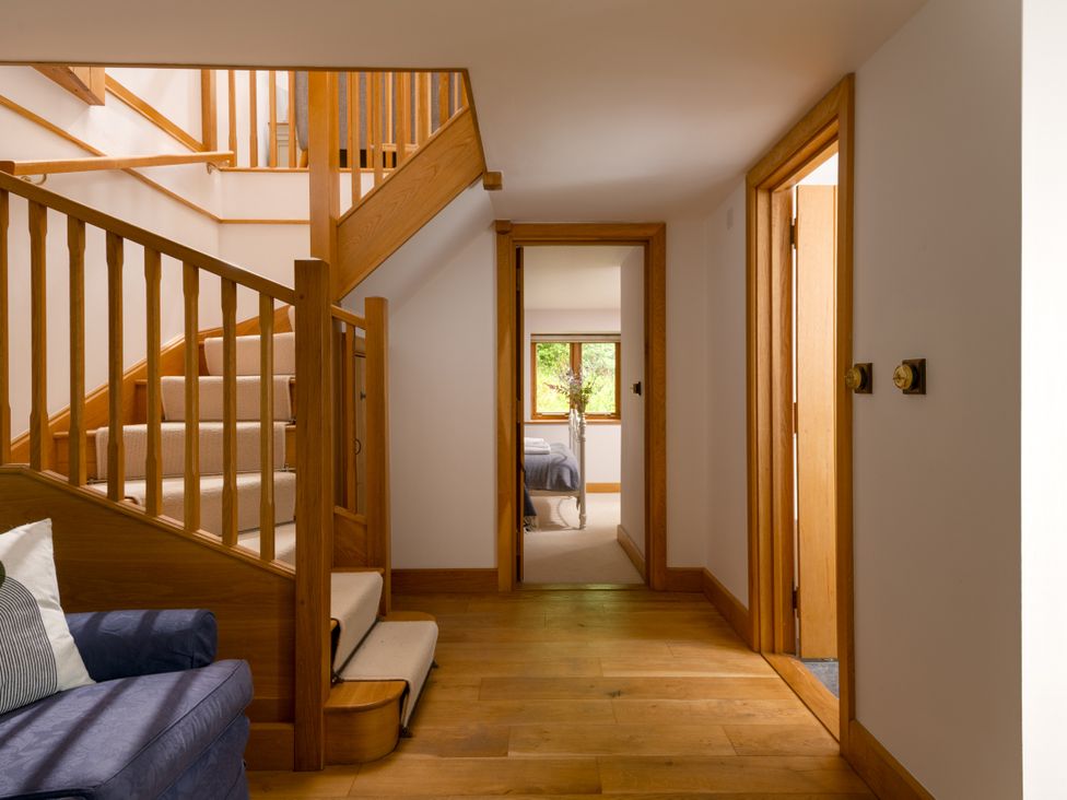 A hallway with stairs and doors at Hoppers Barn in Pancrasweek near Holsworthy
