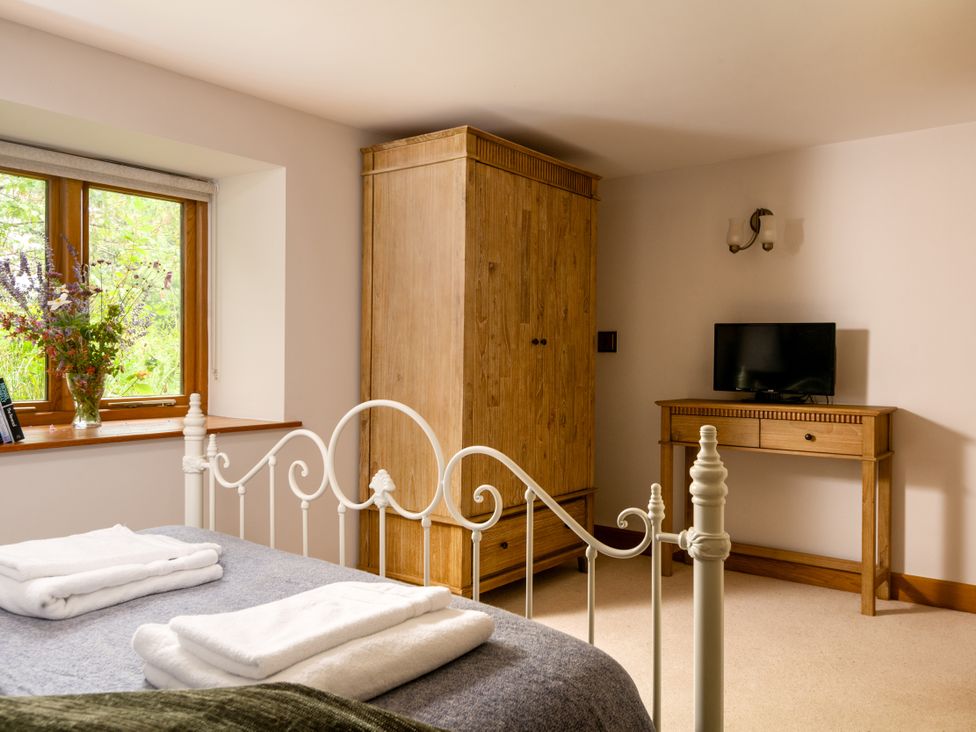 A bedroom with a bed and wardrobe at Hoppers Barn Pancrasweek near Holsworthy