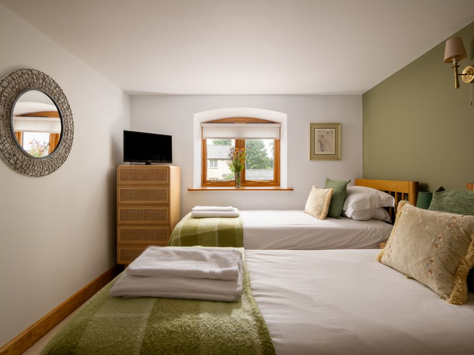 A bedroom with two beds and television at Hoppers Barn Pancrasweek near Holsworthy