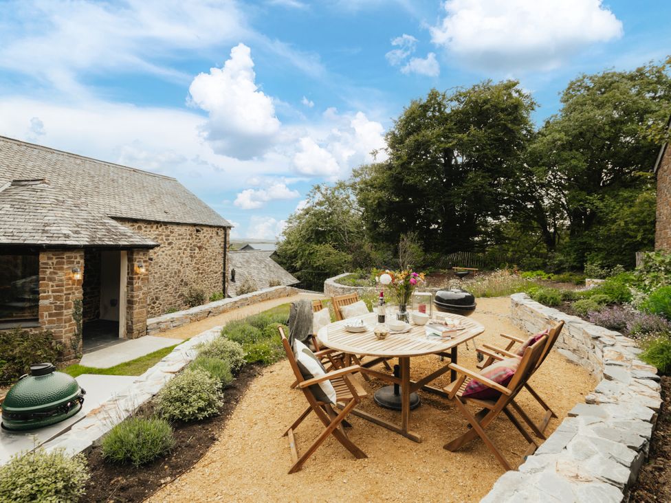A garden with a table and chairs at Hoppers Barn Pancrasweek near Holsworthy