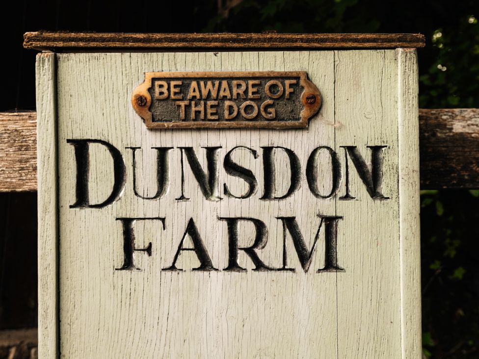 A sign that reads Dunsdon Farm with a warning about a dog
