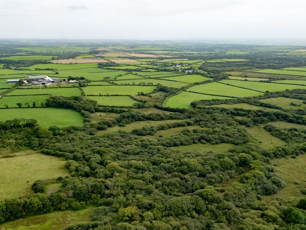 An aerial view of fields and woodland at Hoppers Barn in Pancrasweek near Holsworthy