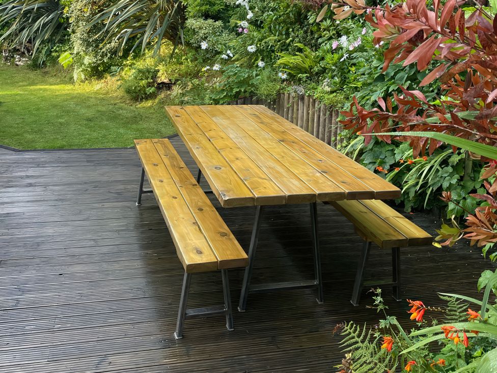 A table and bench set in a garden at Hillsview, Combe Martin
