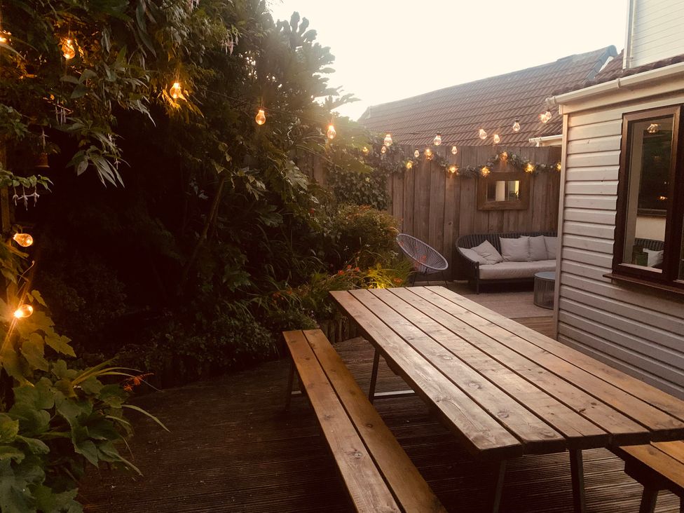 A garden with a table, benches, and outdoor lights at Hillsview in Combe Martin