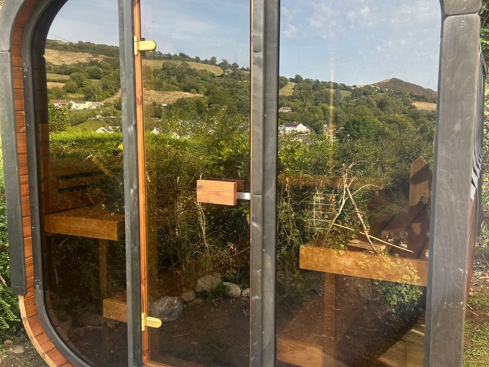 A structure with a glass door and benches at Hillsview in Combe Martin