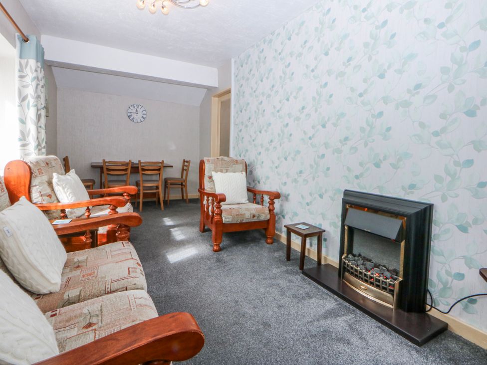 A living room with seating and a dining area at First Floor Apartment in Tremadog