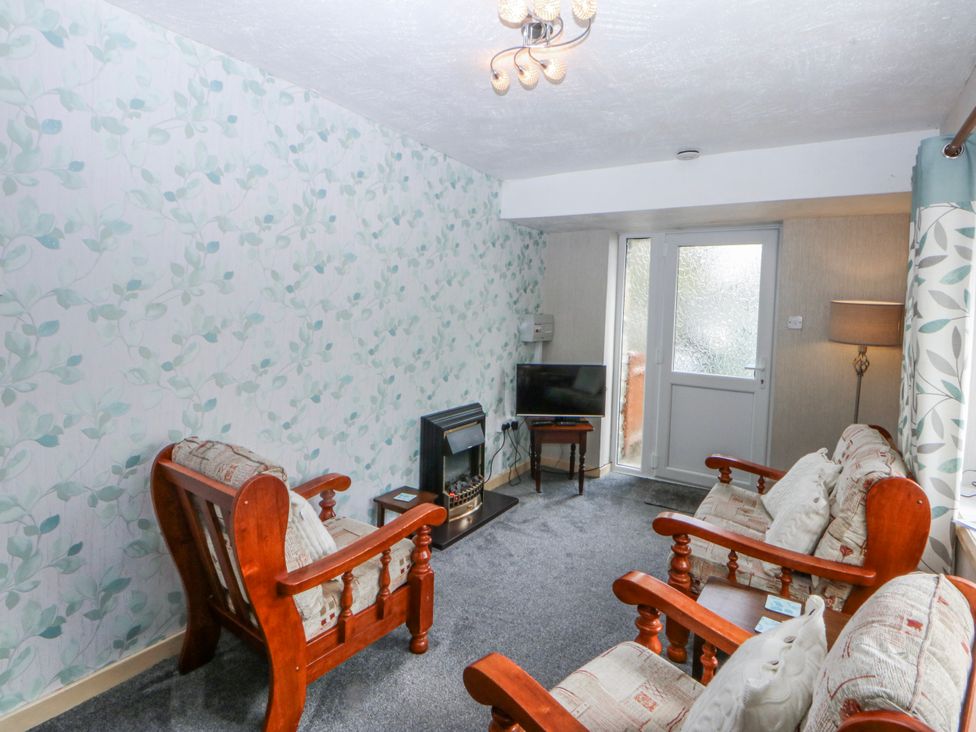 A living room with a sofa and TV at First Floor Apartment in Tremadog