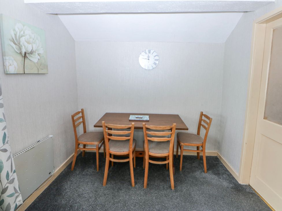 A dining room with a table and chairs at First Floor Apartment in Tremadog