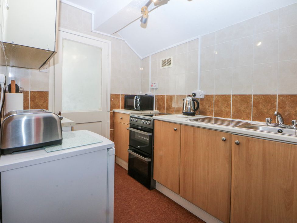 A kitchen with a toaster, electric kettle, and oven at First Floor Apartment in Tremadog