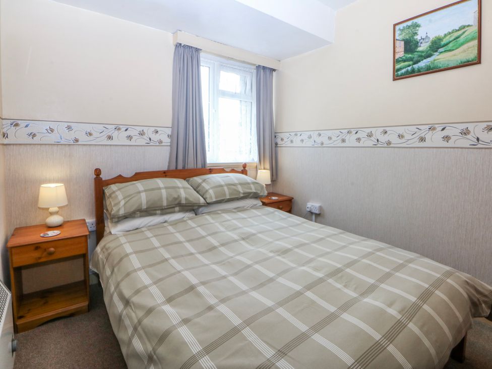 A bedroom with a bed and nightstand at First Floor Apartment Tremadog