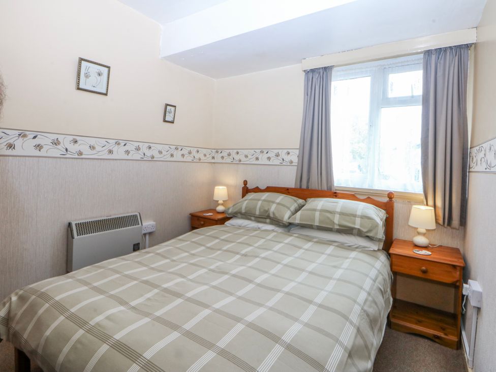 A bedroom with a bed and bedside table at First Floor Apartment in Tremadog