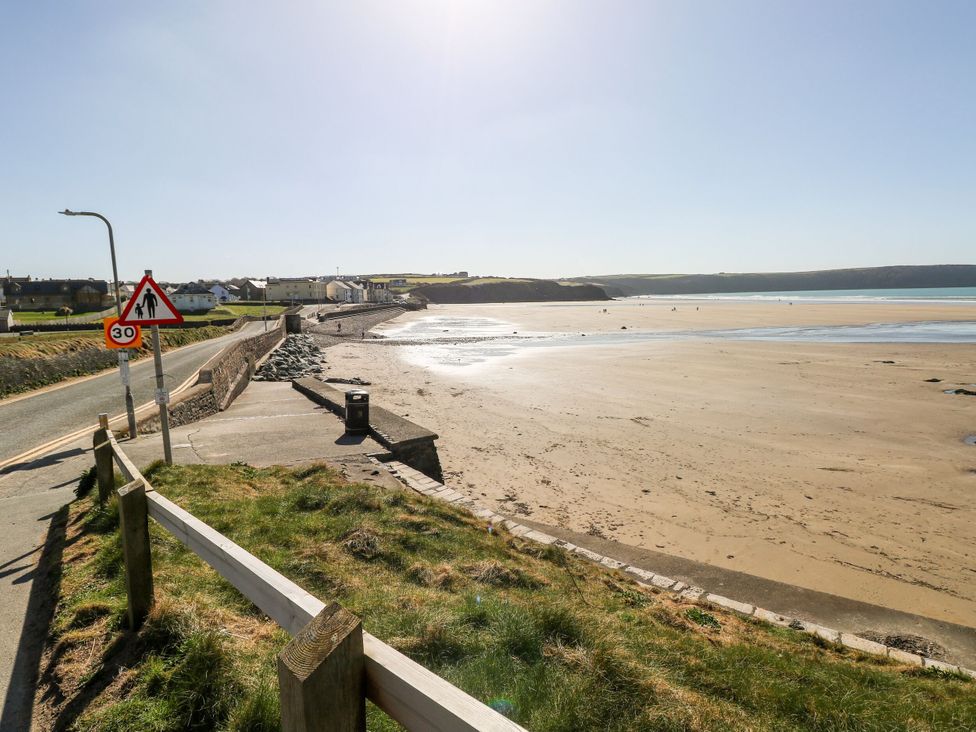 A beach view with sand and water at Reef Retreat in Broad Haven