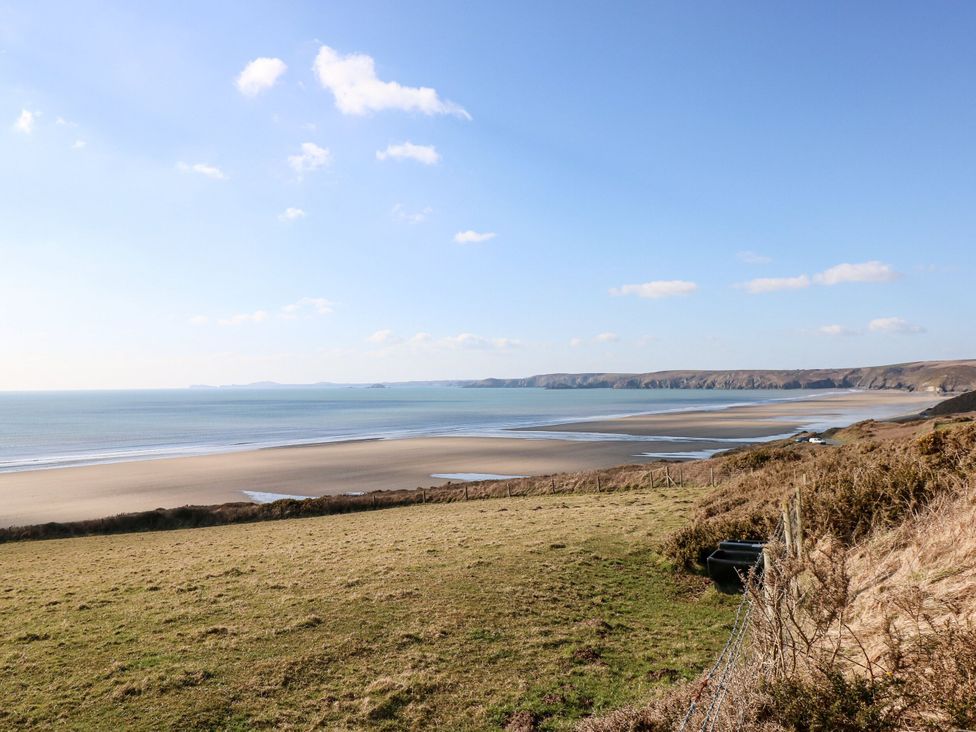 A beach with sand and ocean at Reef Retreat in Broad Haven