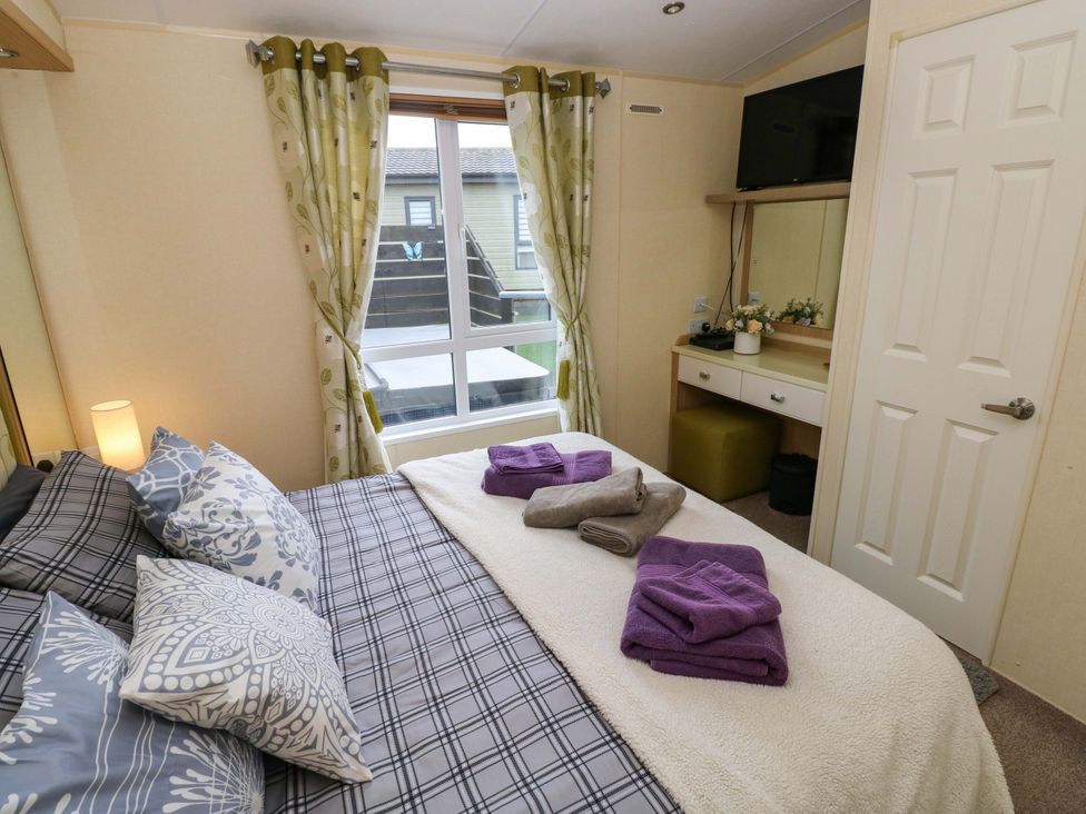 A bedroom with a bed and towels at Reef Retreat in Little Haven