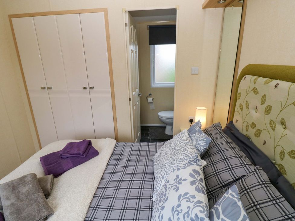 A bedroom with a bed and wardrobe at Reef Retreat in Little Haven