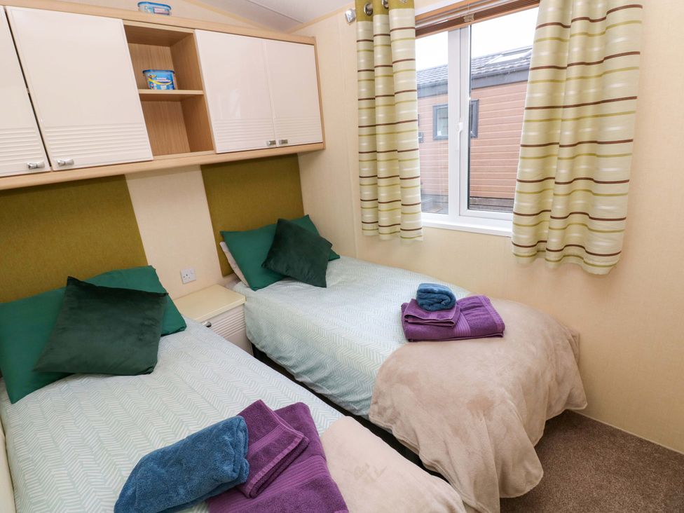 A bedroom with twin beds and towels at Reef Retreat in Little Haven