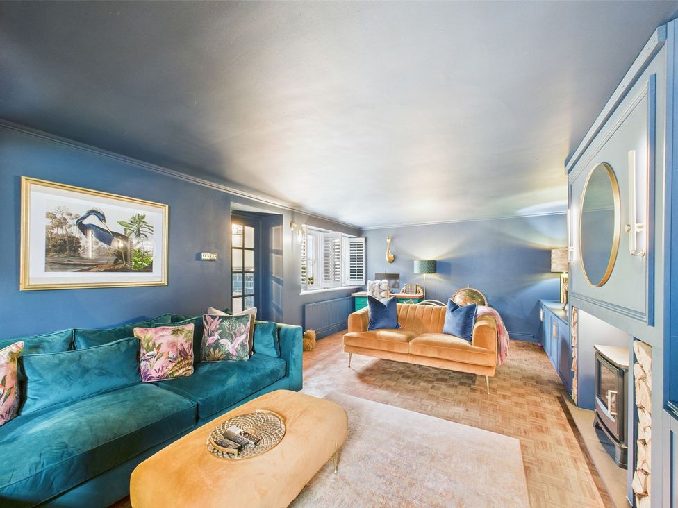 A living room with a green sofa and orange armchair at The Smithy in Barnard Castle